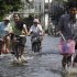 Thai residents smile as they ride their bicycles along flooded streets in Bangkok, Thailand, Sunday, Nov. 6, 2011. Thailand's record high floods continue to creep closer to the heart of the capital. (AP Photo/Aaron Favila) (AP Photo/Aaron Favila)