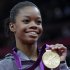 FILE - In this Aug. 2, 2012 file photo, U.S. gymnast Gabrielle Douglas displays her gold medal during the artistic gymnastics women's individual all-around competition at the 2012 Summer Olympics in London. Douglas is back in the gym.The Olympic all-around champion was to practice Monday afternoon, May 20, 2013 after meeting with coach Liang Chow to discuss her comeback plan. The workout is in her old gym in West Des Moines, Iowa.  (AP Photo/Julie Jacobson, File)