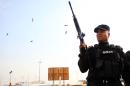 A member of Iraq's security forces fires ammunition in the air during the funeral procession of a member of parliament killed in a suicide blast, on October 15, 2014 in Baghdad