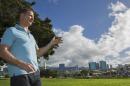 In this Tuesday, Dec. 24, 2013 photo, Robert Perkinson, an associate professor at the University of Hawaii at Manoa, talks about the possible location in the Kakaako district of Honolulu to be considered for the Barack Obama Presidential Library. The plot of land can be seen to the far right. (AP Photo/Eugene Tanner)