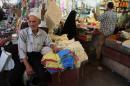 In this photo taken on June 17, 2014, people shop at a market in Baghdad, Iraq. While the Iraqi capital is not under any immediate threat of falling to the Sunni militants who have captured a wide swath of the country's north and west, battlefield setbacks and the conflict's growing sectarian slant is turning this city of 7 million into an anxiety-filled place waiting for disaster to happen. (AP Photo/Karim Kadim)