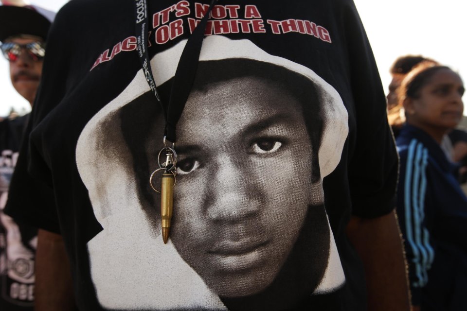 An image of Trayvon Martin and a bullet shell keychain hanging from a protester's lanyard are seen during a demonstration in reaction to the acquittal of neighborhood watch volunteer George Zimmerman on Monday, July 15, 2013, in Los Angeles. Anger over the acquittal of the U.S. neighborhood watch volunteer who shot dead an unarmed black teenager continued Monday, with civil rights leaders saying mostly peaceful protests will continue this weekend with vigils in dozens of cities. (AP Photo/Jae C. Hong)