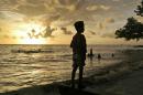In this Friday, March 6, 2015, file photo, a Muslim boy stands on Kastela Beach during sunset in Ternate, North Maluku, Indonesia. (AP Photo/Dita Alangkara, File)