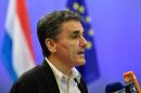 Greek Finance Minister Euclid Tsakalotos answers journalists after a meeting of the Eurogroup on Greece at the European Union headquarters in Brussels on August 14, 2015