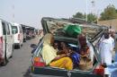 Women and children cram into a car's trunk as villagers flee the village of Jakana, outside Maiduguri, Borno State, Nigeria, on March 6, 2014