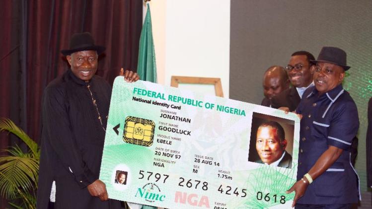 Nigerian President Goodluck Jonathan (L) holds a replica of his electronic ID card with chairman of the board of National Identity Management Commission Uche Secoundus during the cards&#39; launch in Abuja, August 28, 2014