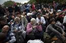 People wait to clear a police line as they entered into Croatia from Serbia, in Babska, Croatia, Friday, Sept. 25, 2015. Croatia lifted its blockade of the border with Serbia on Friday, as southeastern Europe's squabbling governments took steps to ease tensions that had been rising in the region because of the surge of asylum seekers seeking refuge in the rest of Europe. (AP Photo/Marko Drobnjakovic)