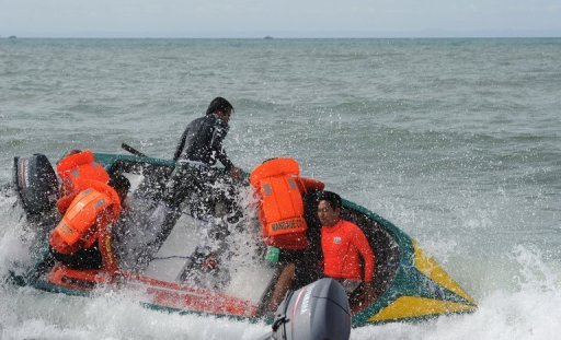 Volunteer rescuers struggle in big waves as they head to the site of a ferry crash near Cebu on August 18, 2013