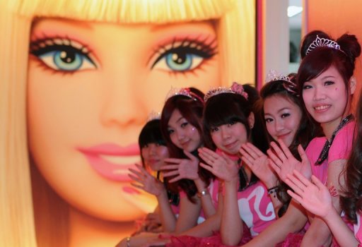 Waitresses wave during the opening ceremony of a Barbie-themed restaurant in Taipei on January 30, 2013