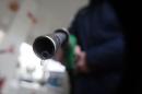 A customer holds a nozzle to fill up his tank in a gasoline station in Nice