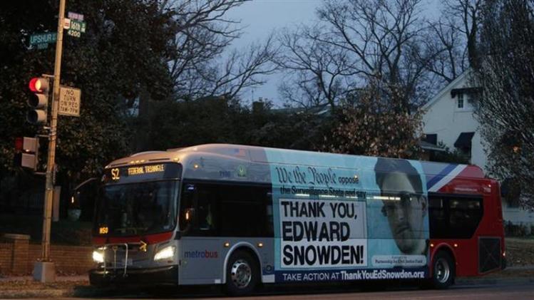 A Washington Metro bus is seen with an Edward Snowden sign on its side panel December 20, 2013. REUTERS/Gary Cameron/Files