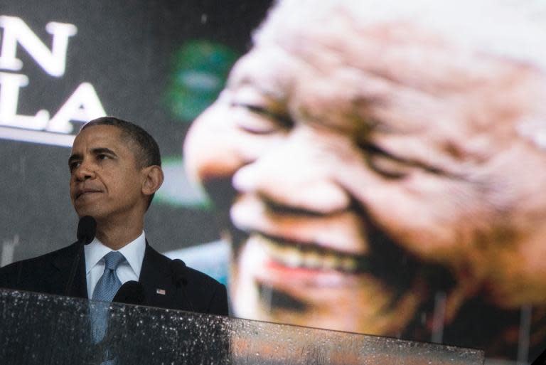US President Barack Obama pauses while speaking during the memorial service for late South African President Nelson Mandela at Soccer City Stadium in Johannesburg on December 10, 2013