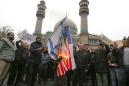 US flags burn as thousands mourn general in Tehran