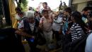 Caravan migrants break Guatemala border fence, rush Mexico
