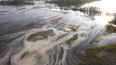 NC river swirls with gray muck near flooded coal ash dump
