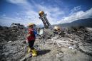 Indonesia mulls leaving quake-flattened villages as mass graves