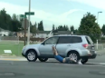 Carjacker in America dragged down street with trousers falling off