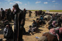 Heads bowed to the ground, suspected IS members surrender
