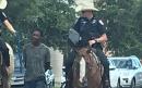 Texas police condemned after officers on horseback lead black suspect by rope